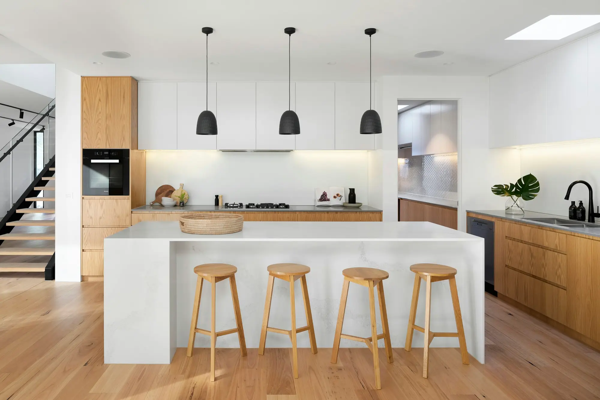 Cocina reformada, luminosa, con isla, madera y lámparas colgantes
